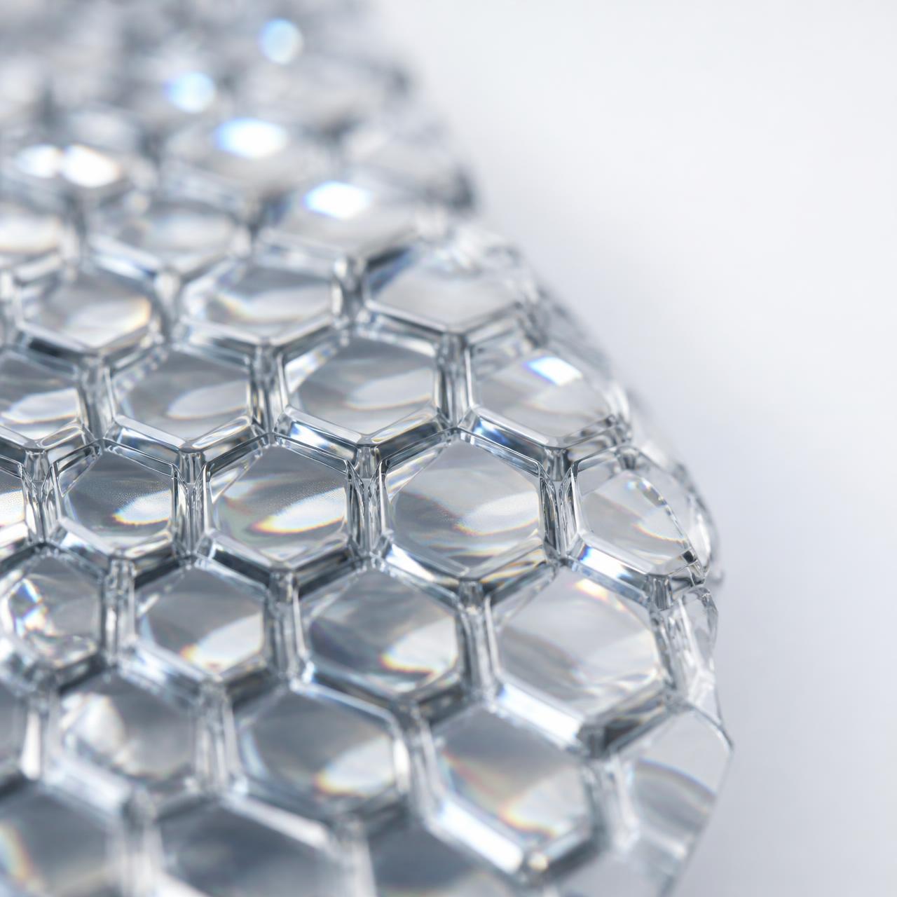Macro photograph of light refracting through a hexagonal microlens array film